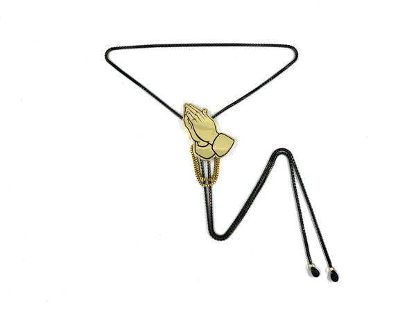 Praying hands bolo tie with black and gold box chain and black glass tips on a white background