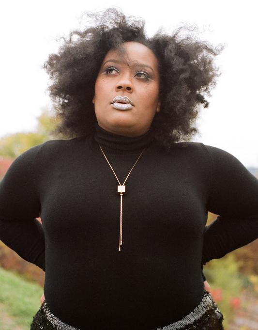 Model wearing gold cube bolo tie necklace