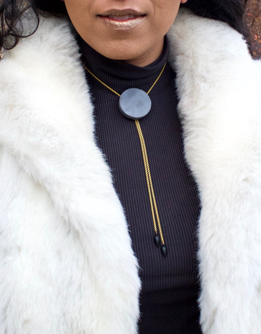 Concrete bolo tie necklace close up on a model