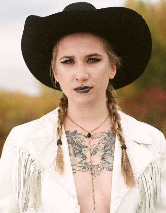 Model wearing gold lariat necklace
