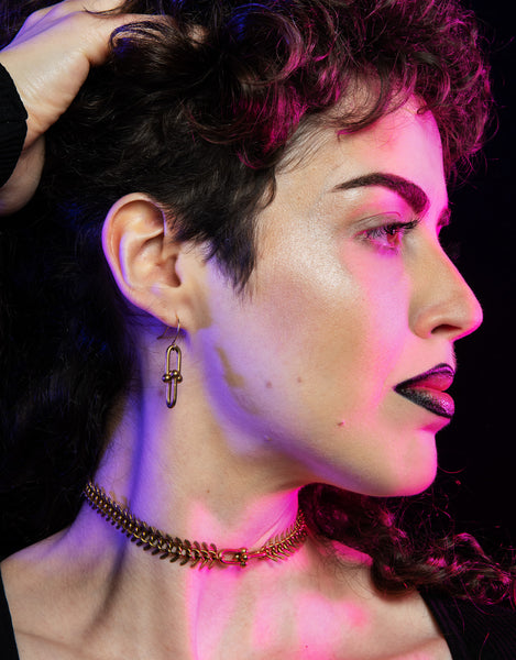 Side view of model wearing hardware chain link earrings and matching choker