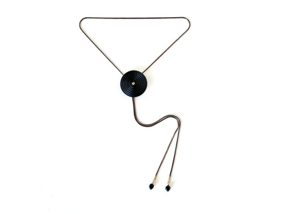 Black bolo tie necklace with circle medallion and goldstone bolo tips