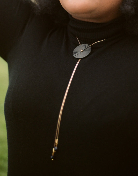Close up of black bolo tie necklace 