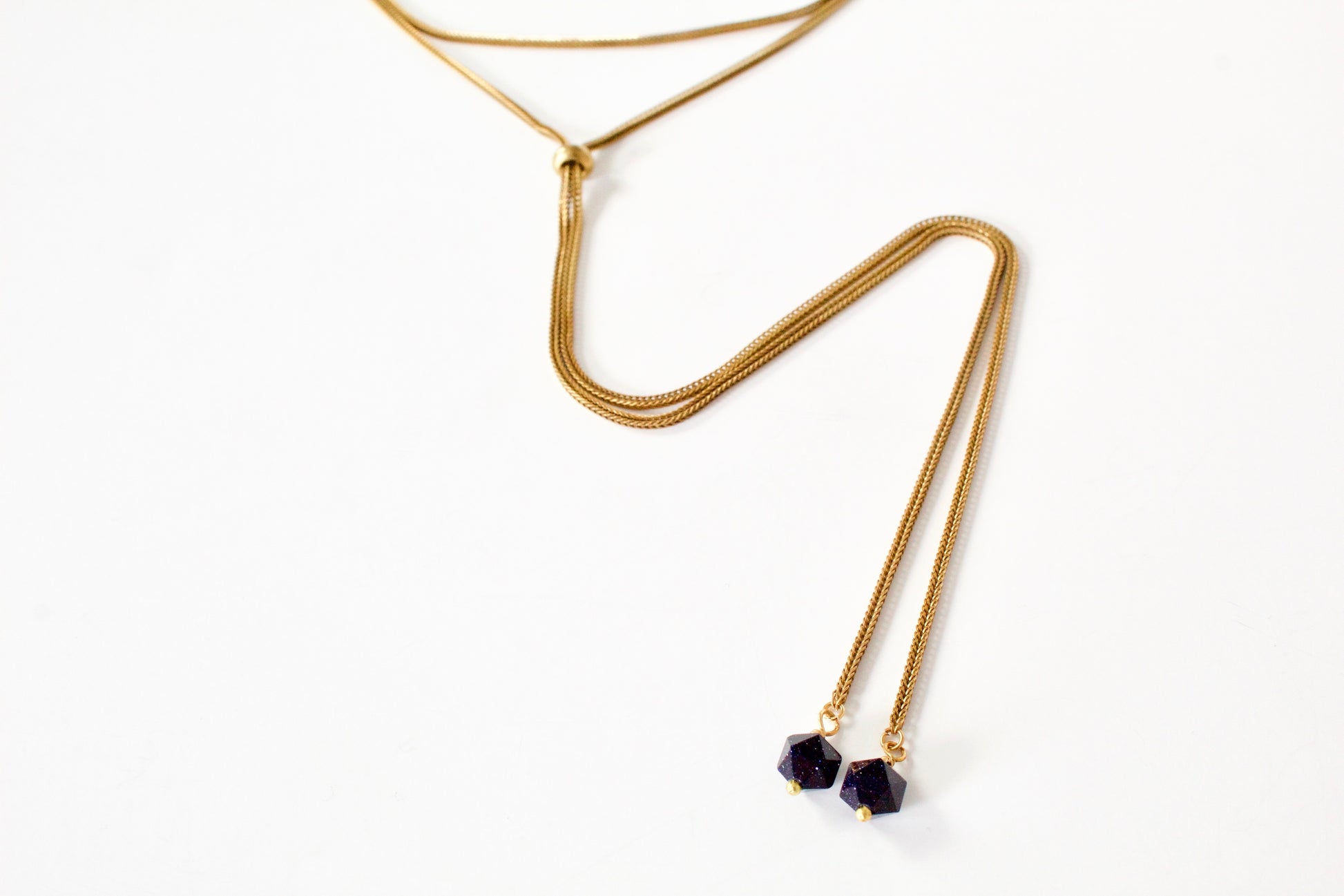 Close-up of brass foxtail chain and goldstone tips of necklace