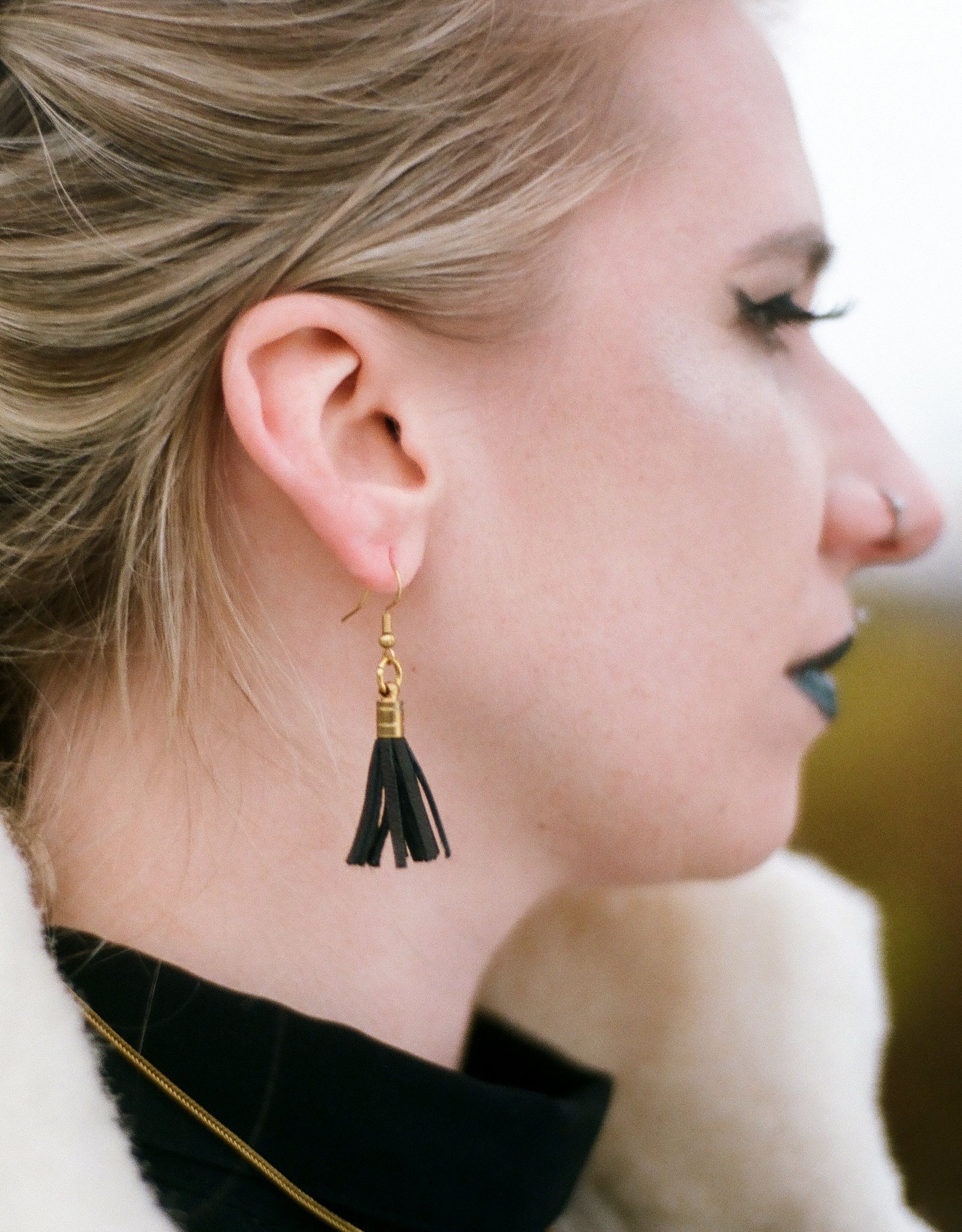 Side view of leather tassel earrings on model
