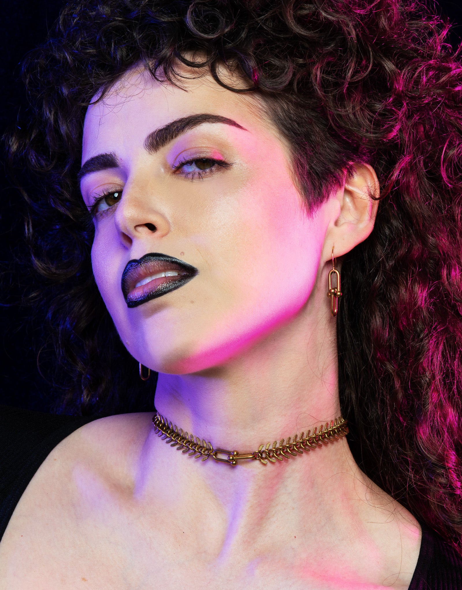 Model wearing fishbone choker with hardware chain link pendant and hardware earrings