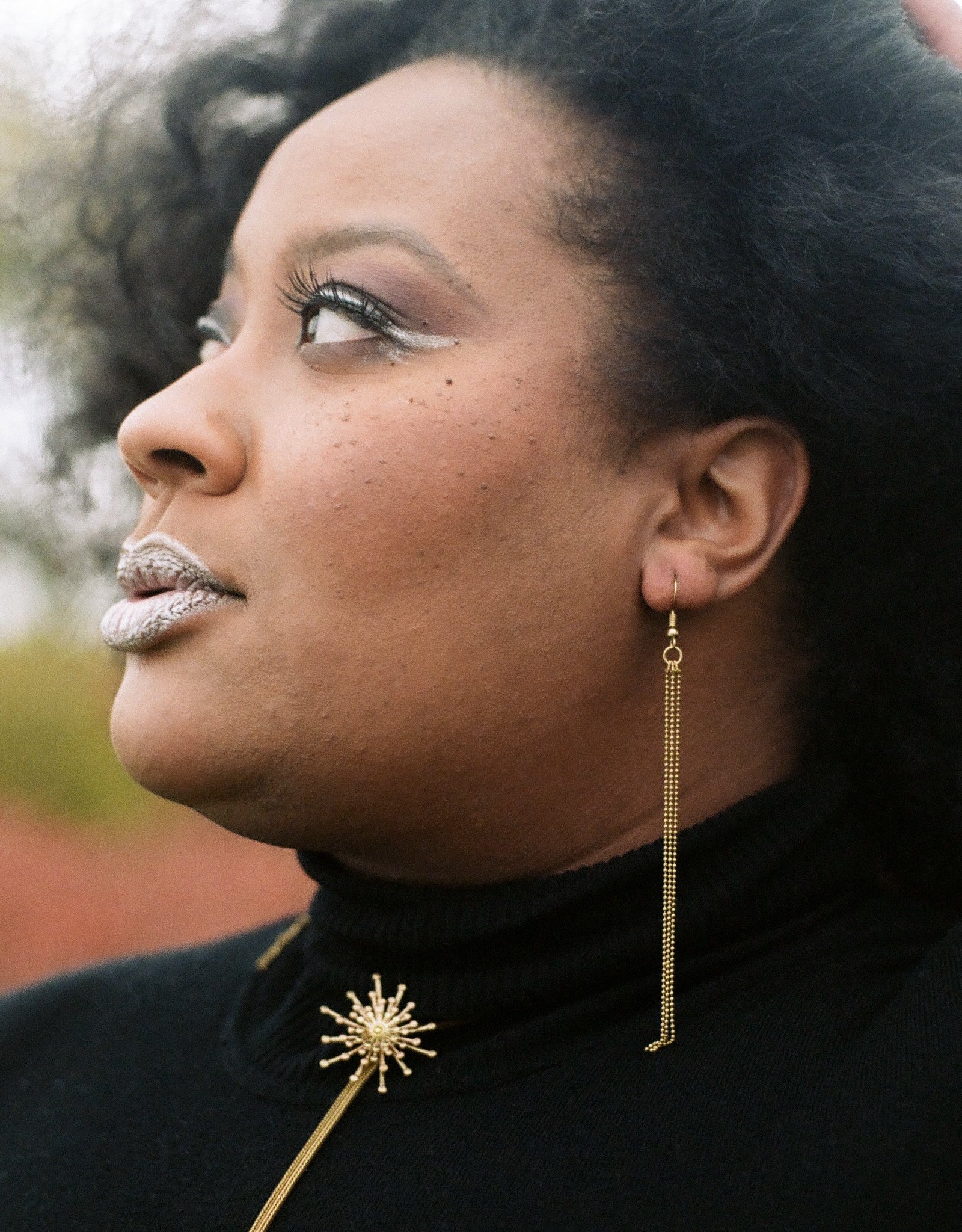 Close-up of delicate tassel earrings on a model