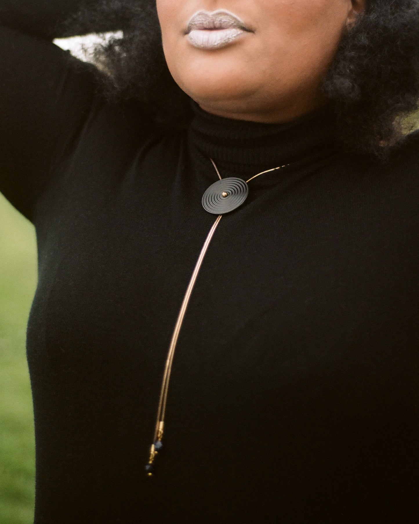 Side view of model wearing bolo tie necklace