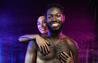 Model wearing black bolo tie necklace while being held by second model
