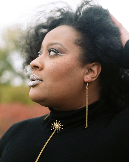 Model wearing gold ball chain tassel earrings and STARBURST Bolo Tie Necklace
