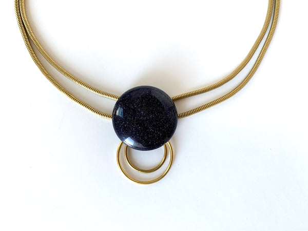 Blue goldstone pendant with brass o rings hanging from below
