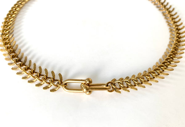 Close up of hardware pendant of gold fishbone choker necklace