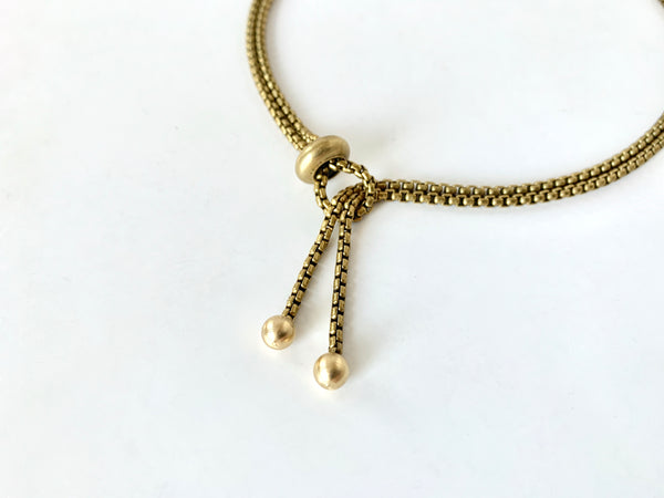 Gold tips of adjustable chain necklace with slide bead