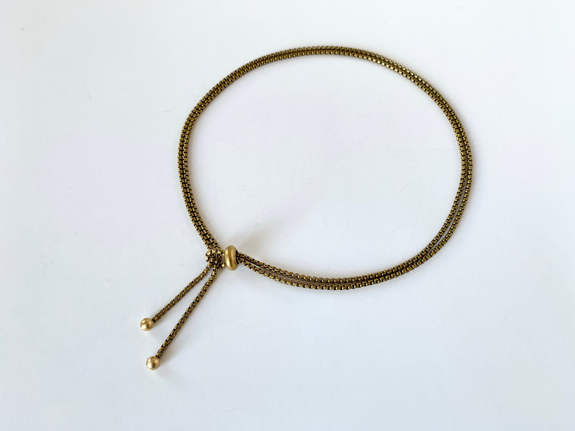 Rolo chain lasso style necklace with slide bead and round gold tips