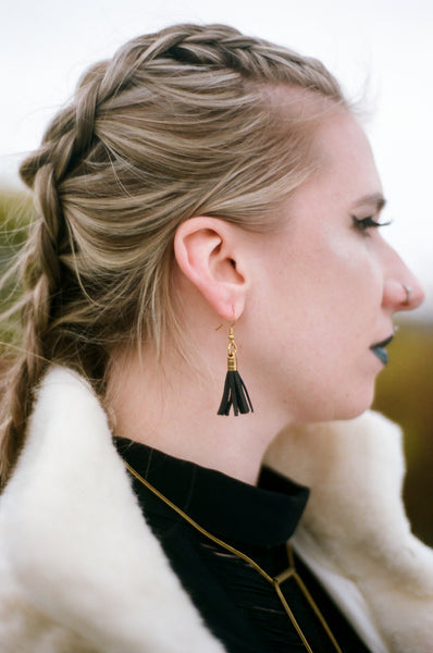 Model wearing leather tassel earrings