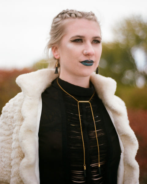 Model wearing matching matching leather tassel necklace and earrings