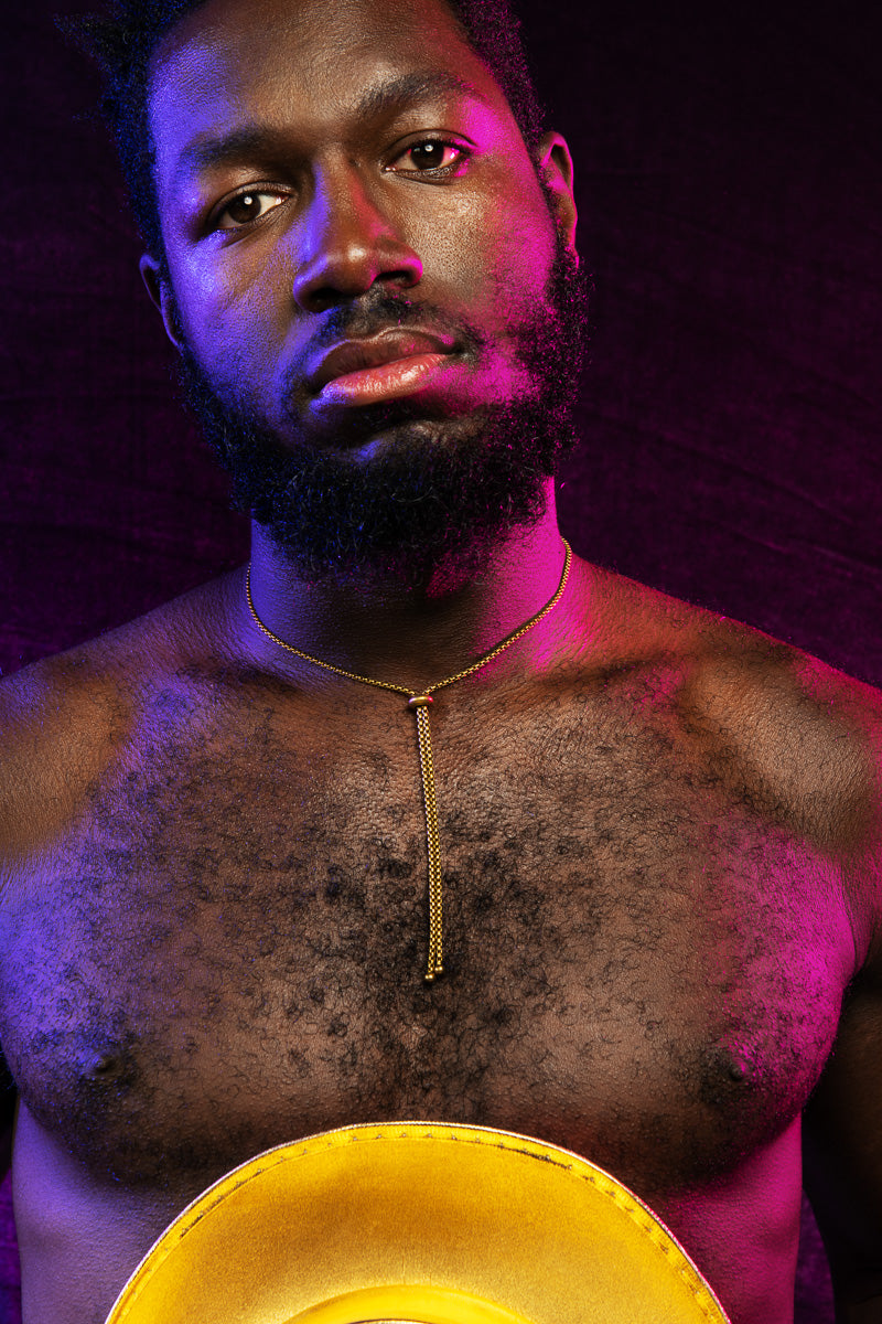 Model wearing gold bolo tie necklace