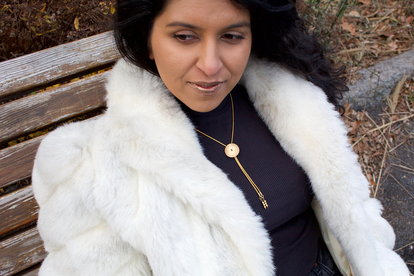 Model wearing small gold bolo tie necklace