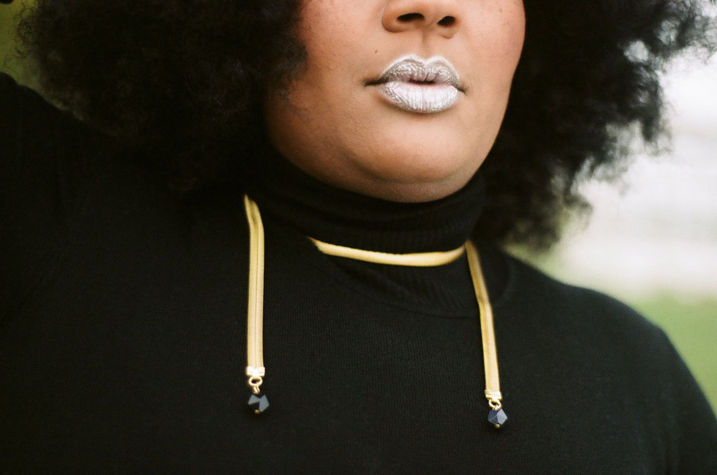 Close-up of snake chain necklace on model