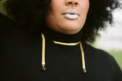 Close-up of snake chain necklace on model