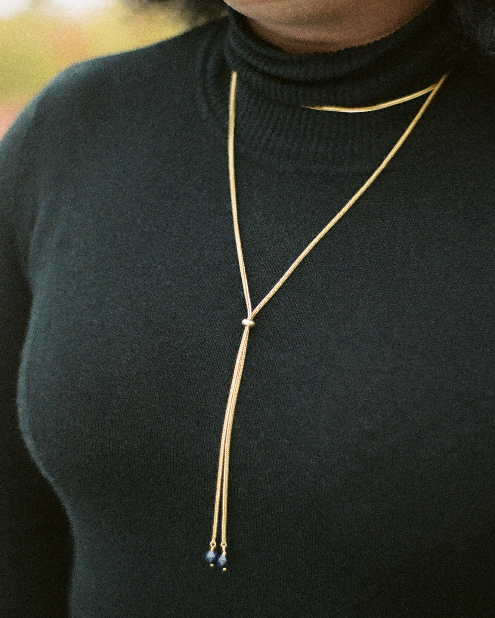 Close-up of foxtail chain necklace on a model